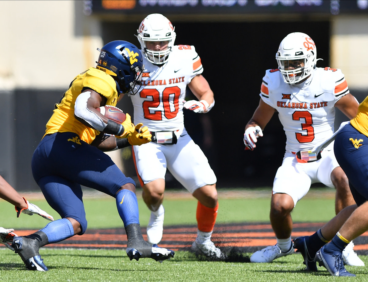 Rodriguez (20) and safety Tre Sterling (3) poised to make a tackle on West Virginia running back Leddie Brown.